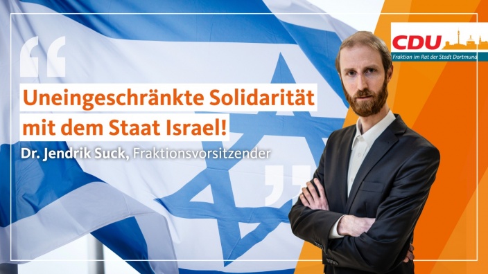 Auf diesem Bild sehen Sie den Fraktionsvorsitzenden Dr. Jendrik Suck vor einer Israel-Flagge.